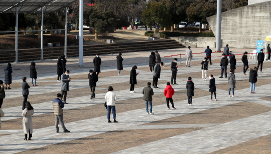 28일 광주 서구 시청광장에 마련된 임시 선별검사소에 코로나19 검사를 받으려는 시민들이 사회적 거리두기를 이행하며 줄 서 대기하고 있다.  연합뉴스